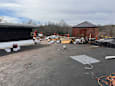 A construction site with a black building and a red brick structure in the background.