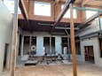 A construction site with a large open space and wooden beams on the ceiling.