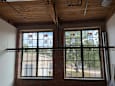Two windows in a room with brick walls and wooden ceiling.