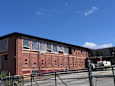 A large brick building with a fence in front.