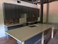 A large table is in a room with a brick wall and a counter.