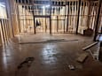 A room under construction with a lot of wood and a pair of scissors on the floor.