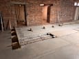 A room under construction with exposed brick walls and a concrete floor.
