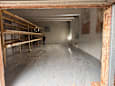 A man is standing in a large, empty room under construction.