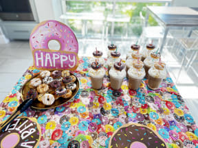 a table topped with cupcakes and donuts and a happy birthday sign on it