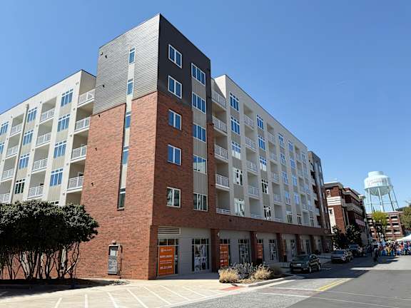 A large multi-story building with a parking lot in front.