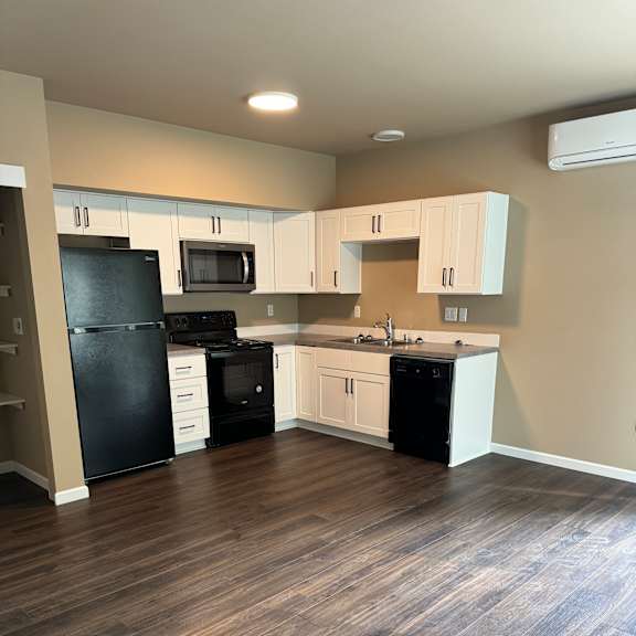 A wood floor with a white cabinet and drawers.