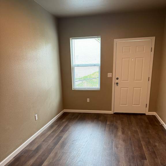 A room with a window and a wooden wall.