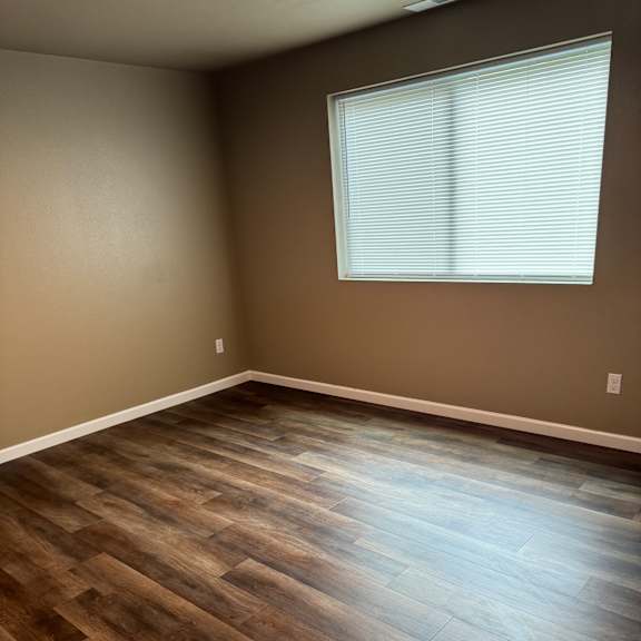 A room with a skylight and wooden flooring.