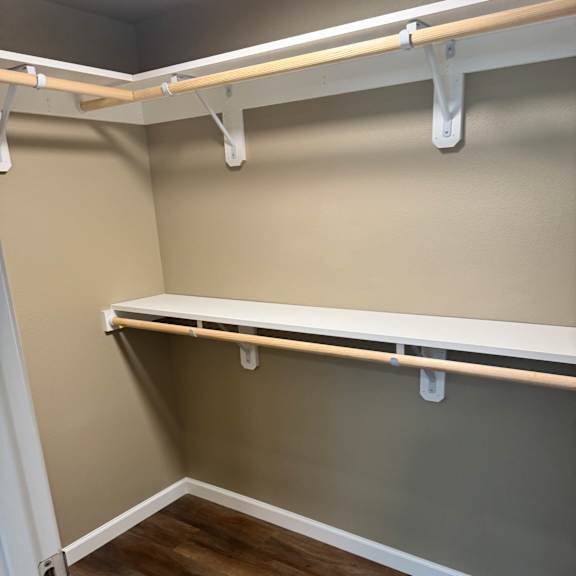 A white ladder with wooden handles is leaning against a wall.