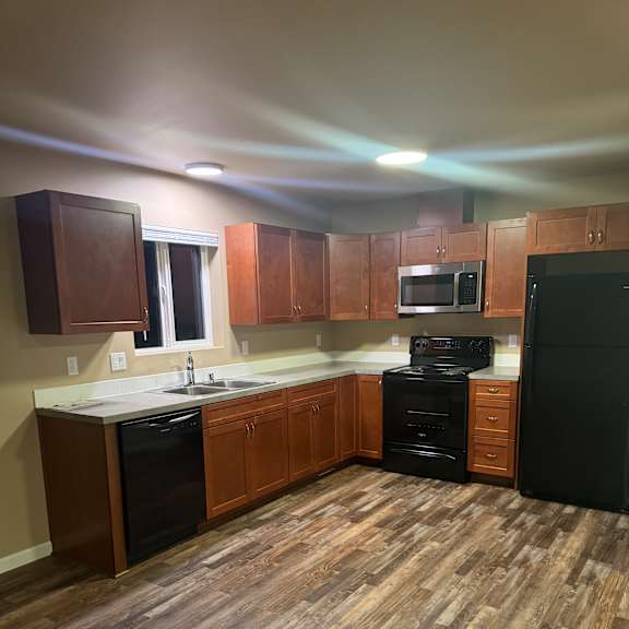 A kitchen with wooden cabinets and a black countertop.