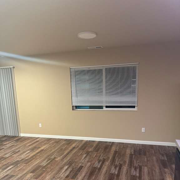 A room with a window and a wooden wall.