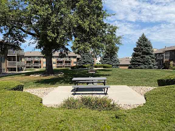 Park near Fox Run Apartments in Omaha, Nebraska with a bench and mature trees