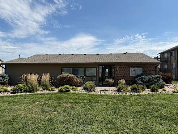 Fox Run Apartments office building in Omaha, Nebraska with brown roof and green lawn