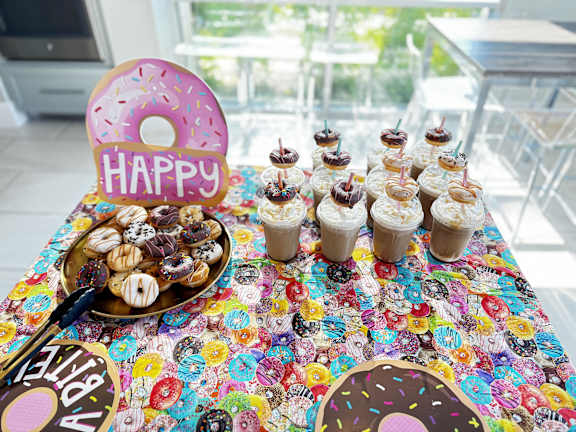 a table topped with cupcakes and donuts and a happy birthday sign on it