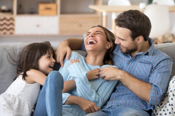 a man and woman sitting on a couch with a daughter
