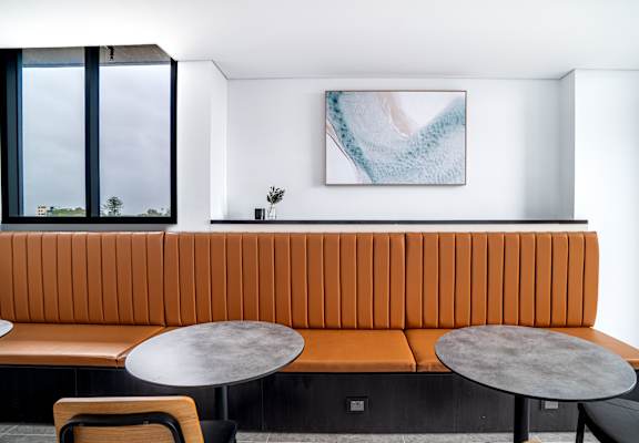 a lounge area with a couch and tables and a window