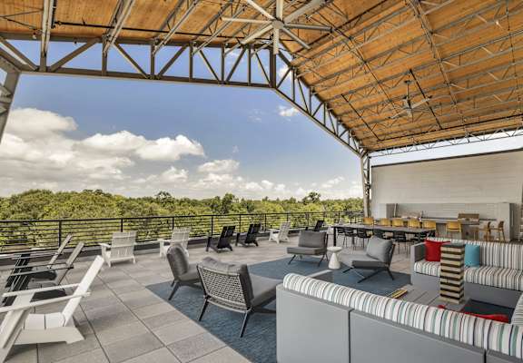 a rooftop patio with couches and chairs and tables