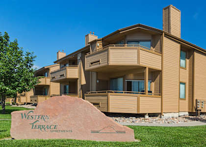 A large house with a sign in front that says Western Terrace Apartments.