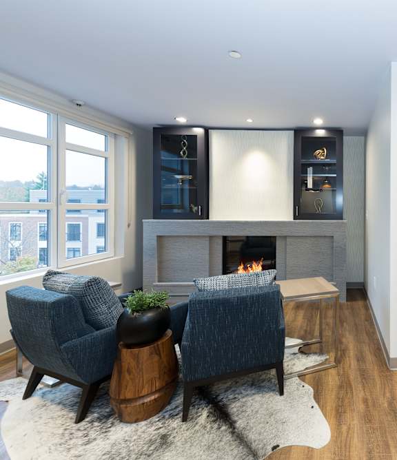 A modern living room with a fireplace and blue chairs.