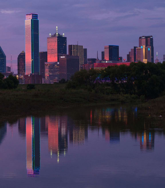 the skyline of the city is reflected in a body of water