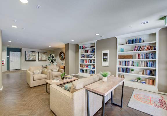 a living room filled with furniture and a large bookshelf at  Ventana Senior Apartments, Porter Ranch ,91326