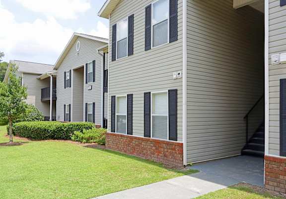 A residential building with a brick base and a grey siding.