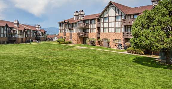 A large building with a green lawn in front.