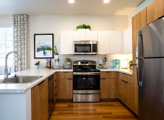 a kitchen with stainless steel appliances and wooden cabinets