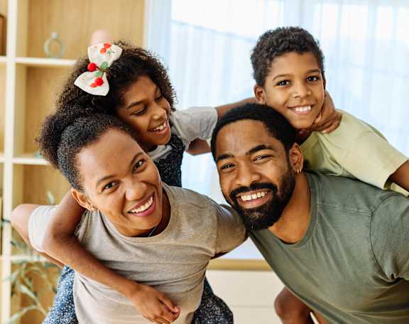 A family of four is having fun together in a room.