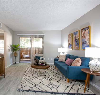 A living room with a blue couch and a wooden cabinet.