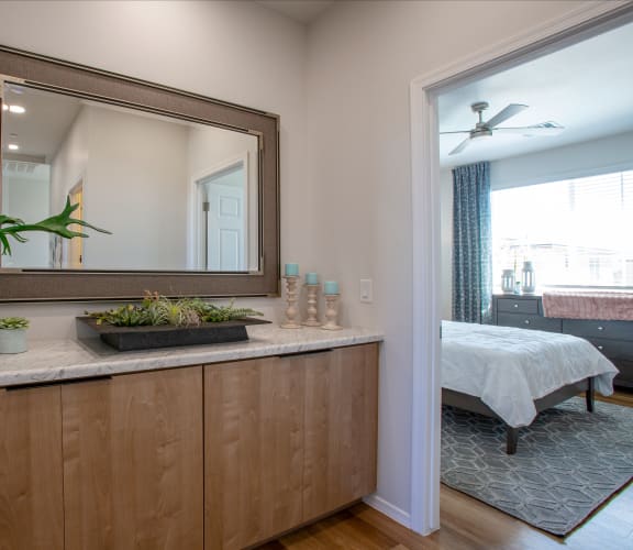 a bedroom with a large mirror and a plant on a counter