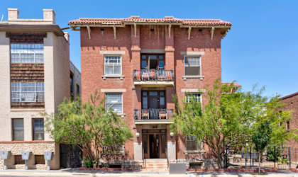 a brick building with two balconies and a street in front