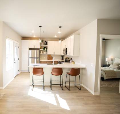 A modern kitchen with a bar stool and a chair.