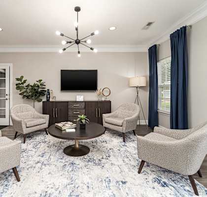 A living room with a large rug and a flat screen TV.
