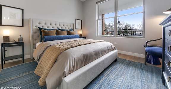 a bedroom with a large window and a bed