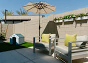 Thumbnail 3 of 4 - A patio with a white chair and a white umbrella.