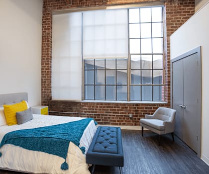a bedroom with a bed and a large window