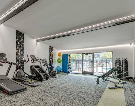 A gym with treadmills, elliptical machines, and other exercise equipment.
