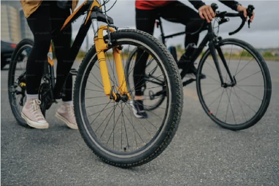 two people riding bikes on the street with their wheels