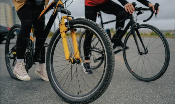 two people riding bikes on the street with their wheels