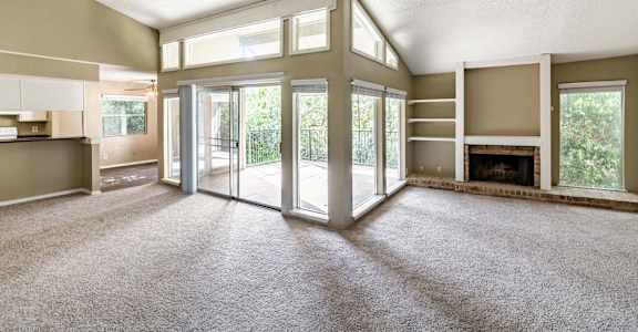 A spacious living room with a fireplace and sliding glass doors.