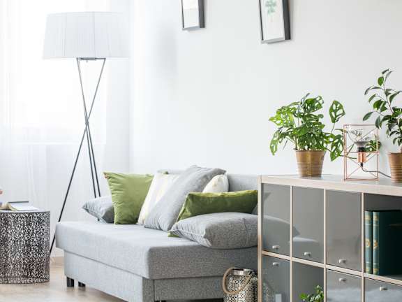 a living room with a grey sofa and green pillows