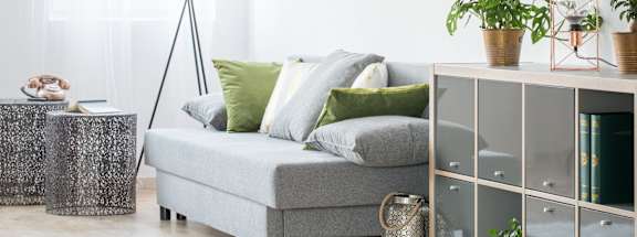 a living room with a grey sofa and green pillows
