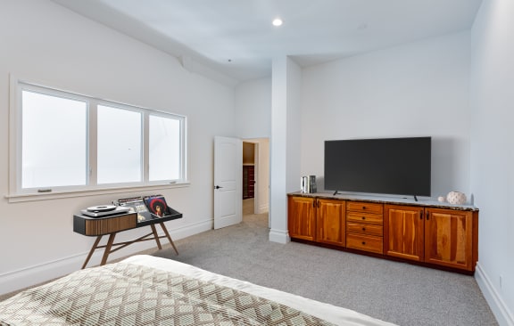a bedroom with a bed and a dresser with a television at Vendome Place, San Jose, CA 95110