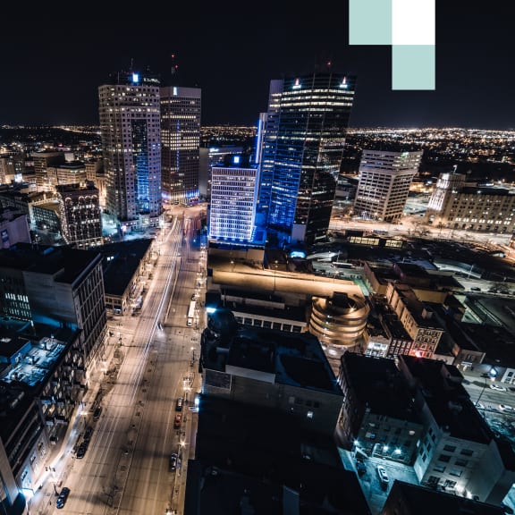 a cityscape at night with blue lights on the buildings