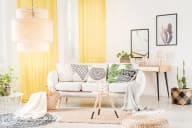 a living room with a white couch and yellow curtains