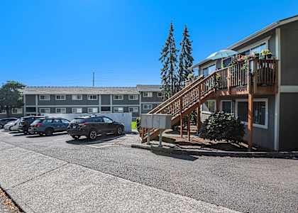 an apartment building with stairs and a parking lot