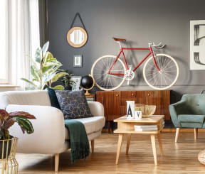 a living room with a couch chair and bicycle hanging on the wall