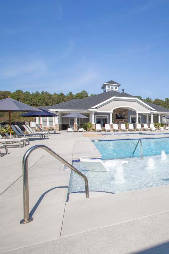 A swimming pool with a slide and a building in the background.